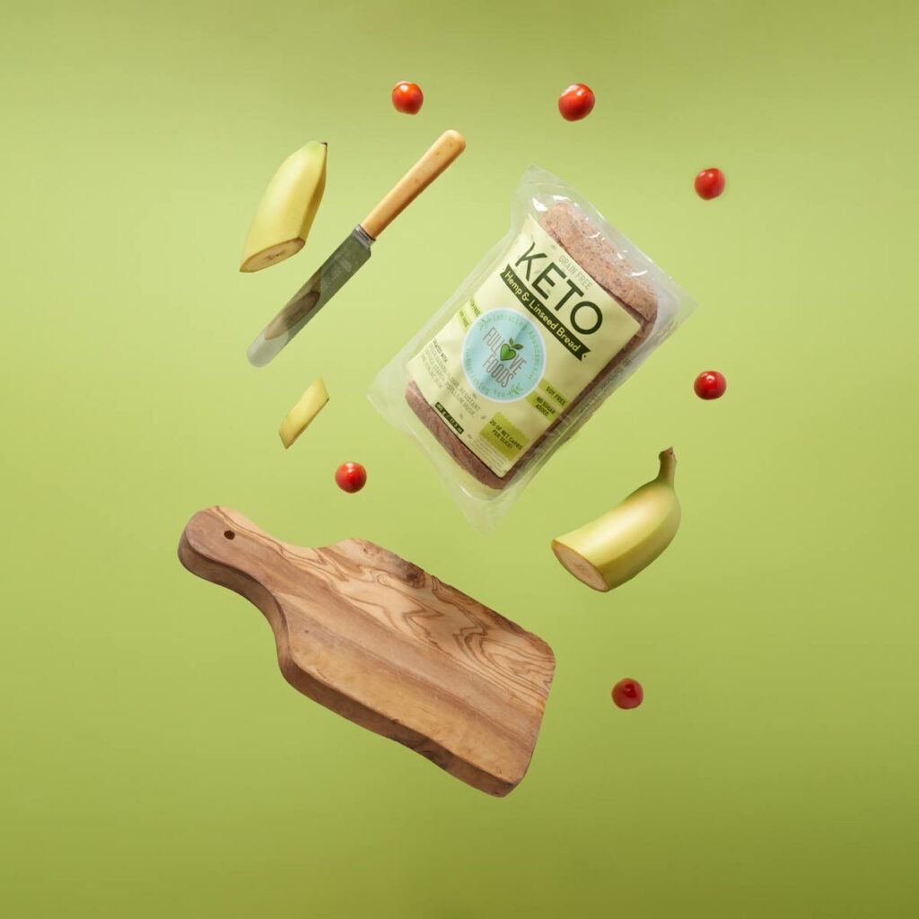 Keto Bread, Wooden Chopping Board With Knife and Fork, Sliced Banana and Cherry Tomatoes