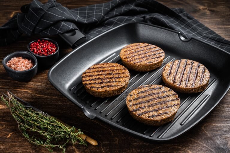 Grilled Vegetarian plant based meat burger patties, vegan cutlets on grill skillet.