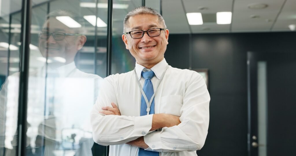 Happy, portrait and businessman with arms crossed in hospital for healthcare services and about us.