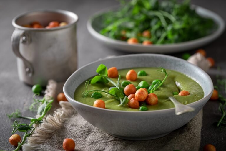 Homemade pea soup with sprouts and peas puff.